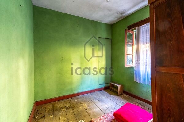 Quarto com paredes verdes, janela e roupeiro